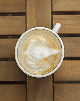 Cup of cappuccino on the table in a cafe, top view