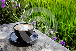 Cup of Cappuccino on a table at an open area cafe on the edge of a rice paddy, Umalas, Bali Island, Indonesia