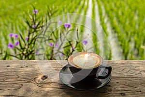 Cup of Cappuccino on a table at an open area cafe on the edge of a rice paddy, Umalas, Bali Island, Indonesia