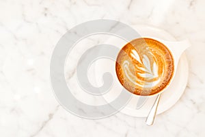 Cup of cappuccino on the white marble table in a modern cafe