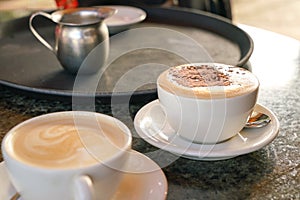 Cup of cappucino and Flat White coffee on table in a cafe photo
