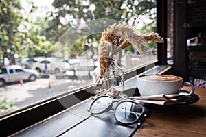 A cup of cappucino on a wood table