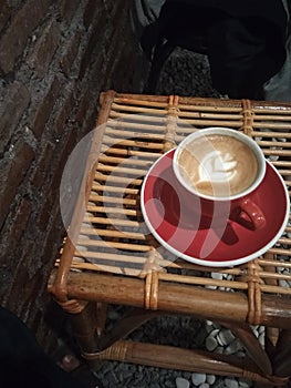 Cup capuccino in glas red rood table