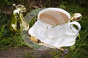 A cup of capuccino in white cup on grass