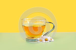 Cup of chamomile tea and chamomile flowers