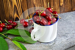 A cup with cherrys on wooden table photo