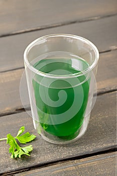 Cup of chlorophyll water on wooden table