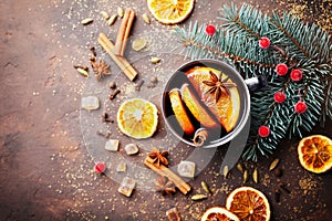 Cup of christmas mulled wine or gluhwein with spices and orange slices on rustic table top view. Traditional drink on winter.