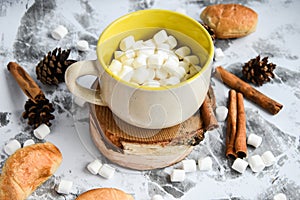 A cup of Christmas New Year delicious hot chocolate and cocoa with marshmallows sprinkled with cocoa powder, cones and croissants