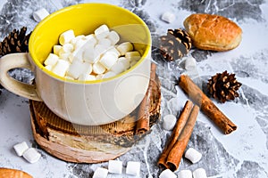 A cup of Christmas New Year delicious hot chocolate and cocoa with marshmallows sprinkled with cocoa powder, cones and croissants