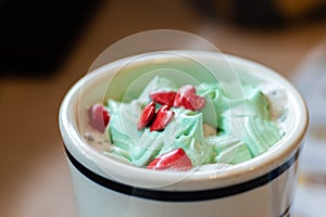 Cup of cocoa with a green whipped cream