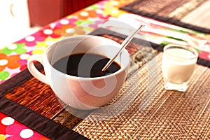 Cup of cofe and cream on bamboo mat