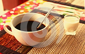Cup of cofe and cream on bamboo mat