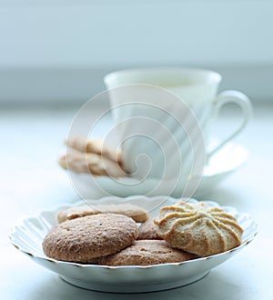 A cup of cofee or tea with biscuits