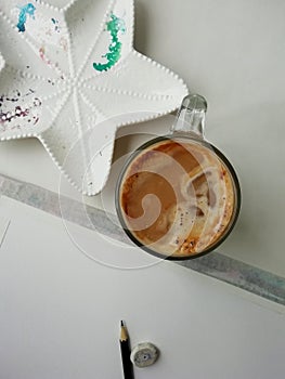 A cup of coffe, ceramic plate for wayercolor and paper with pencil . photo