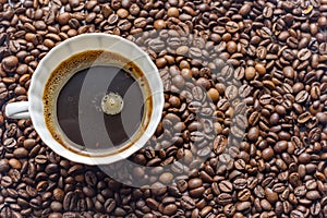 cup of coffe on coffe beans background.