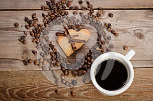 The cup of coffe and Frame-heart from coffee beans and two cookies