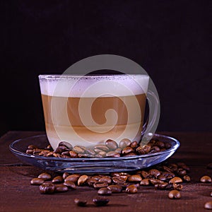 Cup of coffe with milk on a dark background. Hot latte or Cappuccino prepared with milk on a wooden table