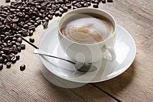 Cup of coffe on a saucer with a vintage spoon