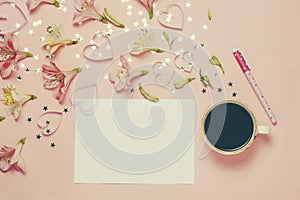 Cup of coffe and spring greeting with a pen, flower composition. top view, flat lay. place for text, copyspace