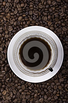 Cup of coffee against beans background closeup