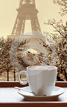 Cup of coffee against Eiffel Tower during spring in Paris, France