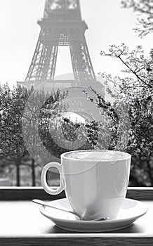 Cup of coffee against Eiffel Tower during spring in Paris, France