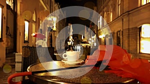 Cup of coffee Autumn evening in city street cafe on table rainy night pink umbrella Old Town Of Tallinn