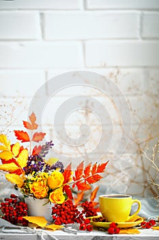 Cup of coffee, autumn leaves and flowers on a wooden table. Autumn still life. Selective focus.