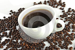 Cup with coffee on a background of coffee beans