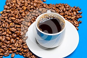 Cup with coffee on a background of coffee beans