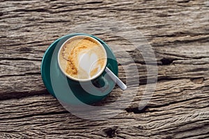 A cup of coffee on the background of an old wooden table A heart for coffee. St. Valentine`s Day concept photo