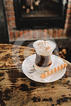 A cup of coffee in a bar, on a vintage rustic wooden table. it is a coffee with chocolate