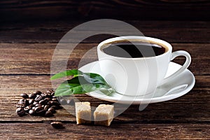Cup of coffee with beans, leaf and sugar
