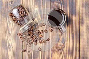 Cup of coffee and beans are scattered from a glass jar