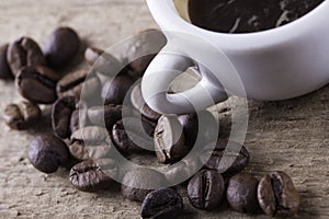 Cup, coffee beans on wooden board closeup top view background