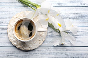 Cup of coffee with beautiful flowers on wooden background