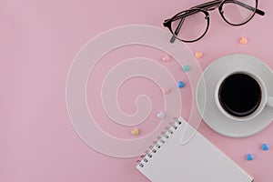 A cup of coffee, blank notebook and eyeglasses