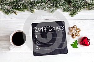 Cup of coffee and board with goals for new year