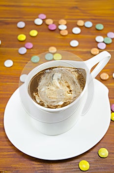 Cup of coffee and bombons of various colors