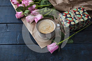 A cup of coffee is on the book. Bouquet of roses. A gift on Valentine`s Day. A special place for text.