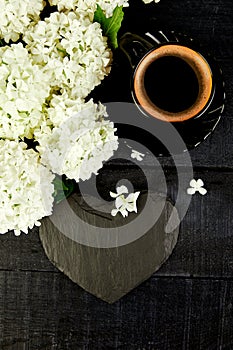 Cup of coffee with bouquet flower hydrangea and slate heart