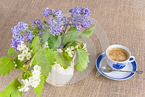 Cup of coffee and bouquet of lilac