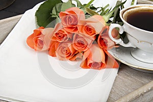 Cup of coffee and a bouquet of roses on a tray