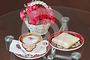 A cup of coffee and bread and flower