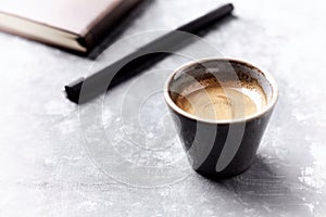 Cup of coffee on bright wooden background.
