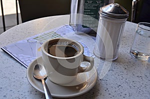 Cup of coffee at Cafe Du Monde in New Orleans French Quarter and map of French Quarter photo
