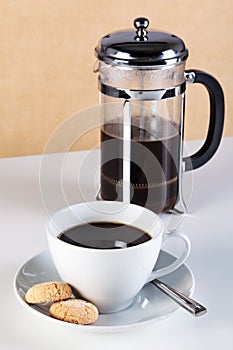 Cup of coffee with cafetiere and amaretti biscuits photo
