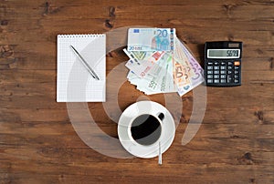 Cup of coffee, calculator, notepad and euro money
