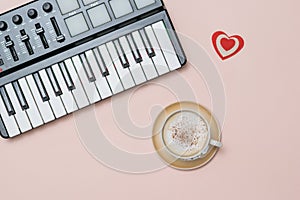 A Cup of coffee cappuccino with cinnamon and a music mixer on a pink background.
